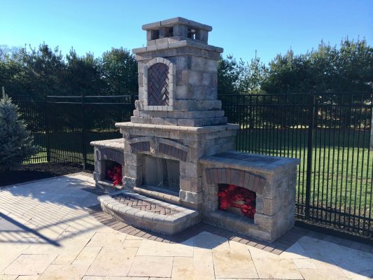 Enhance your outdoor gatherings with Scenic View Landscaping’s bespoke stone fireplace, perfect for any backyard setting.