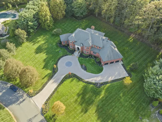 Aerial perspective of a beautifully crafted paver driveway at a spacious suburban home, showcasing the harmony between architecture and landscape design.