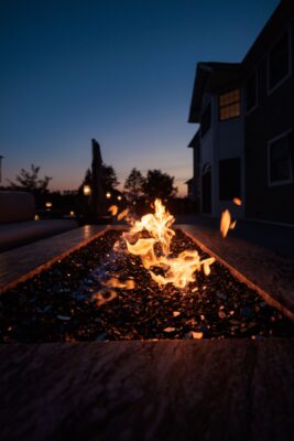 Complete outdoor living makeover in Colts Neck, NJ featuring a custom pool, raised patio, landscape lighting, sod lawn, outdoor kitchen, fire feature, and fully integrated landscape and hardscape design by Scenic View Landscaping.