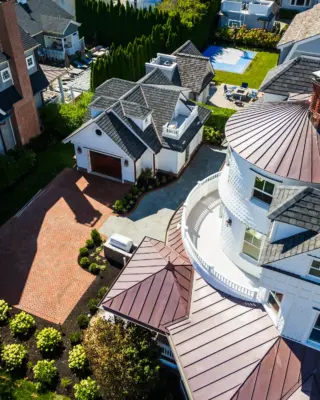 Scenic View Landscaping transformed a Spring Lake property with a complete front and backyard renovation, featuring beach-inspired landscaping, custom lighting, bluestone patio, brick driveway, outdoor kitchen, new sod, drainage, and concrete walkways.