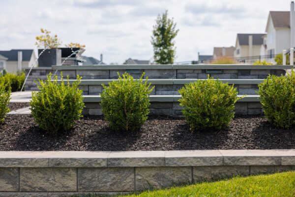 Scenic View Landscaping transformed a Lincroft, NJ property with a natural stone stairway, Techo-Bloc pool hardscaping, covered outdoor living area, and lush new landscaping.