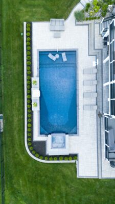 Scenic View Landscaping transformed a Lincroft, NJ property with a natural stone stairway, Techo-Bloc pool hardscaping, covered outdoor living area, and lush new landscaping.