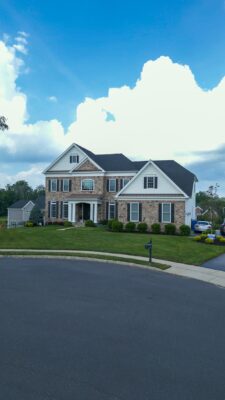 Scenic View Landscaping transformed a Lincroft, NJ property with a natural stone stairway, Techo-Bloc pool hardscaping, covered outdoor living area, and lush new landscaping.