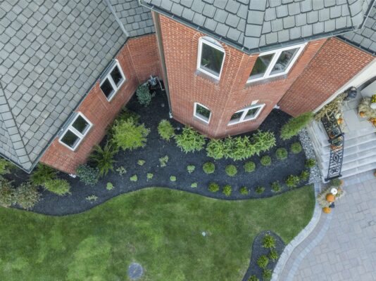 A complete front yard transformation in Colts Neck, NJ featuring a custom paver driveway, entrance steps, and professionally designed landscaping.
