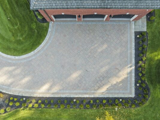 A complete front yard transformation in Colts Neck, NJ featuring a custom paver driveway, entrance steps, and professionally designed landscaping.