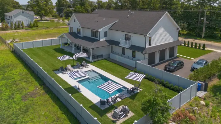 Outdoor living project in Rumson, NJ featuring a covered paver patio, outdoor kitchen, stone steps, natural stone walkway, and fire pit area.