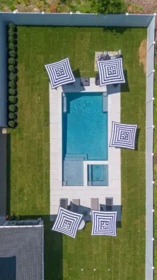 Outdoor living project in Rumson, NJ featuring a covered paver patio, outdoor kitchen, stone steps, natural stone walkway, and fire pit area.