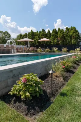 Outdoor living project in Rumson, NJ featuring a covered paver patio, outdoor kitchen, stone steps, natural stone walkway, and fire pit area.