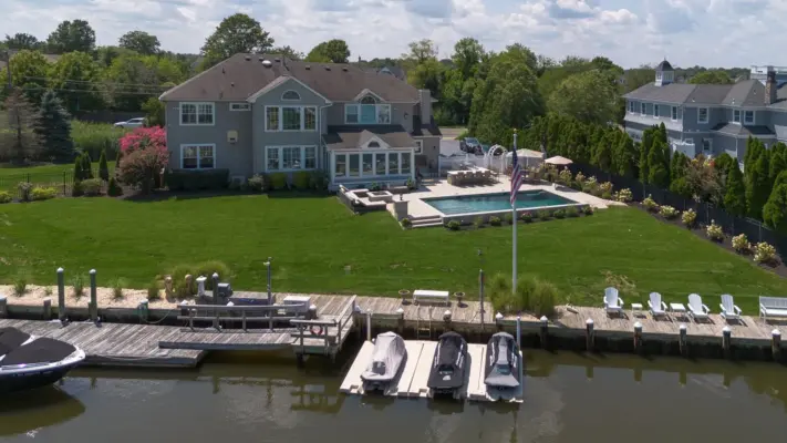 Outdoor living project in Rumson, NJ featuring a covered paver patio, outdoor kitchen, stone steps, natural stone walkway, and fire pit area.